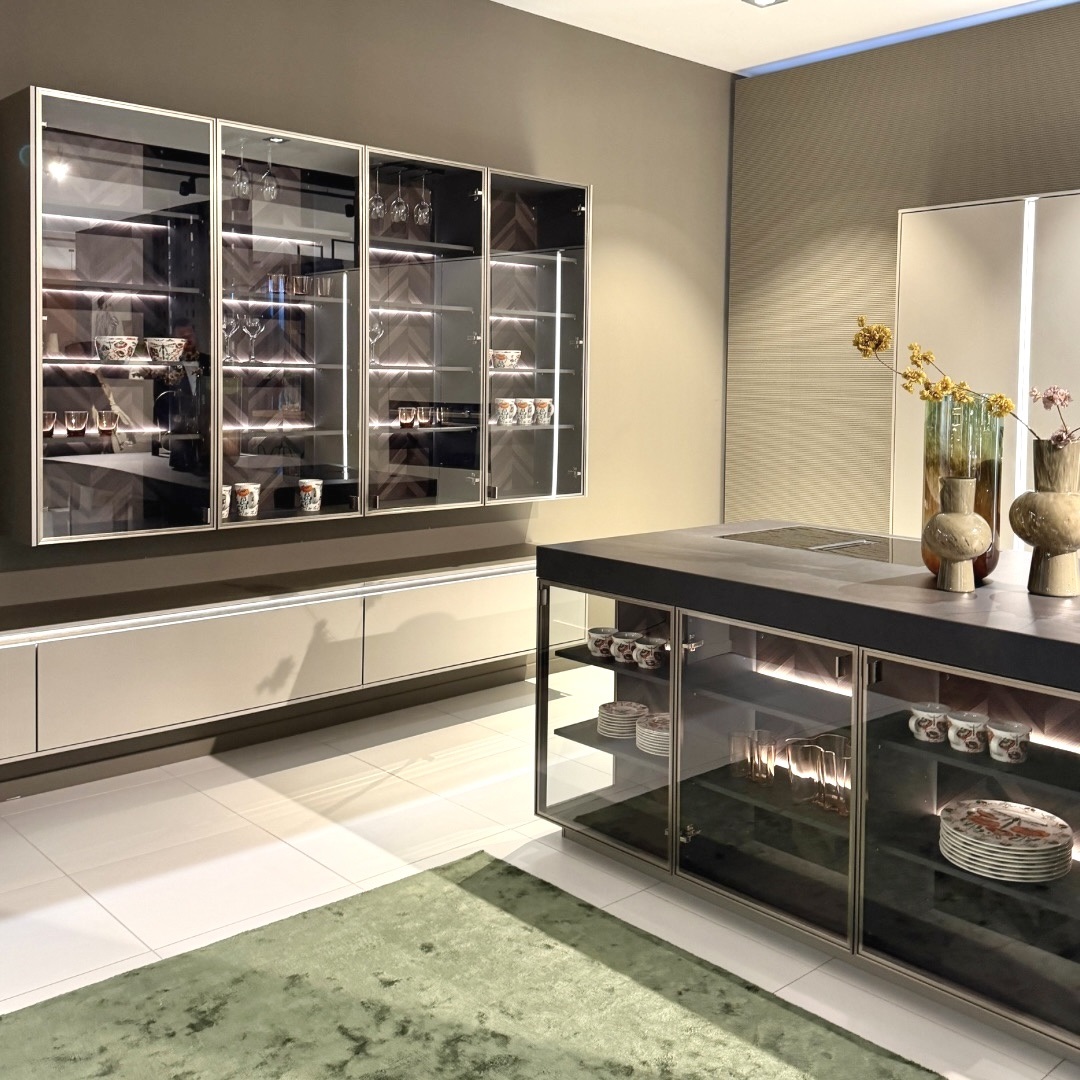 Moderne Küche mit eleganten schwarzen Glasvitrinen und integrierter Beleuchtung, die Geschirr und Gläser stilvoll in Szene setzen.