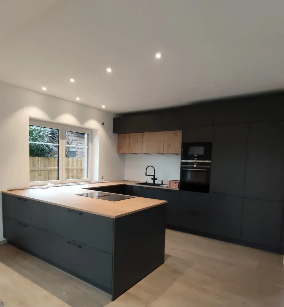 Moderne Häcker systemat Inselküche in Schwarz matt mit Holz-Arbeitsplatte und Hängeschränken in Eicheoptik – Designküche mit Siemens Geräten in Hamburg.