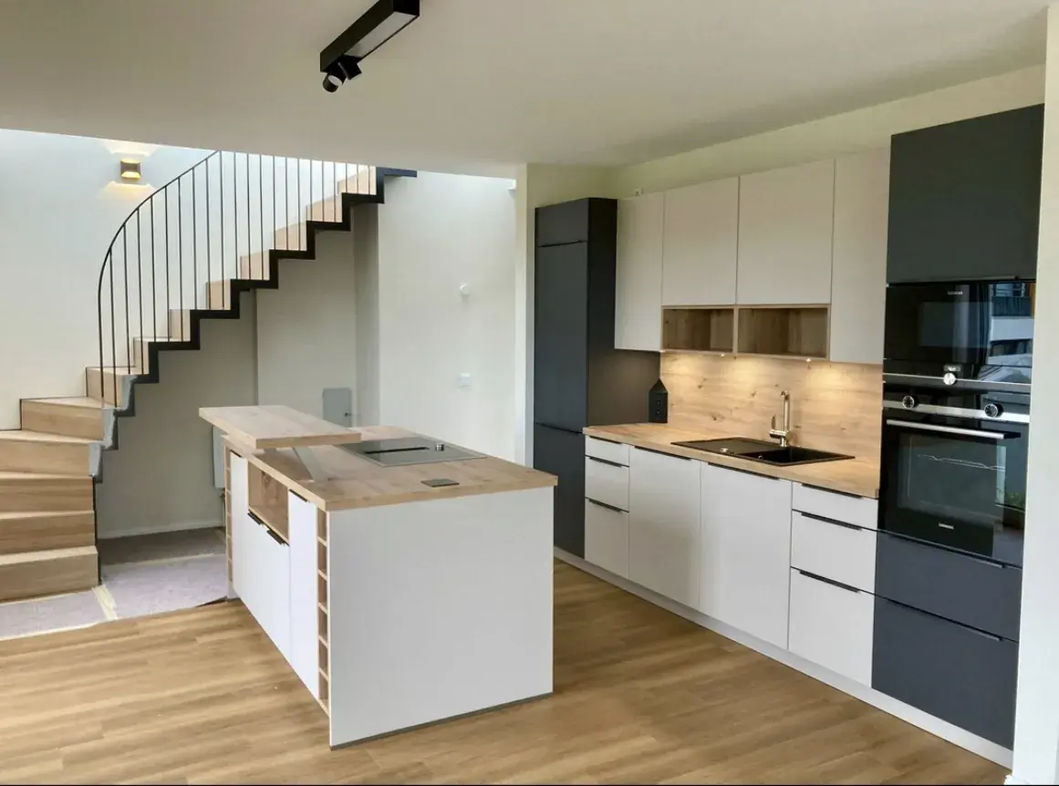 Häcker concept130 Küche in Weiß und Anthrazit mit Kochinsel, Holz-Arbeitsplatte, Barplatte und integriertem Weinregal – moderne Einbauküche in Hamburg.